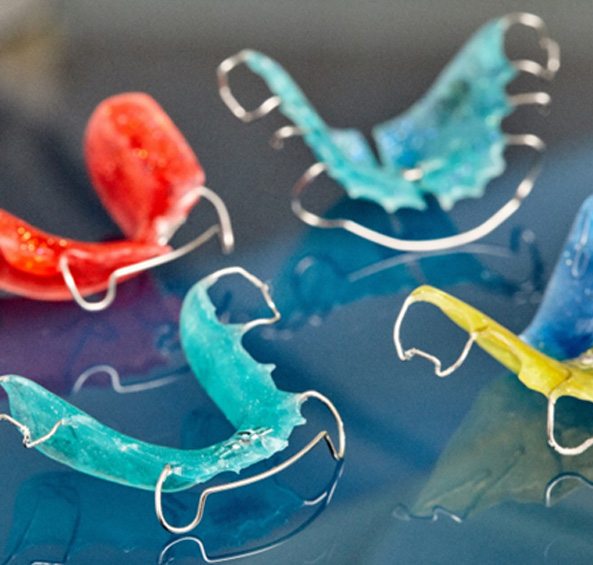 Closeup of four differently colorful retainers in Frisco