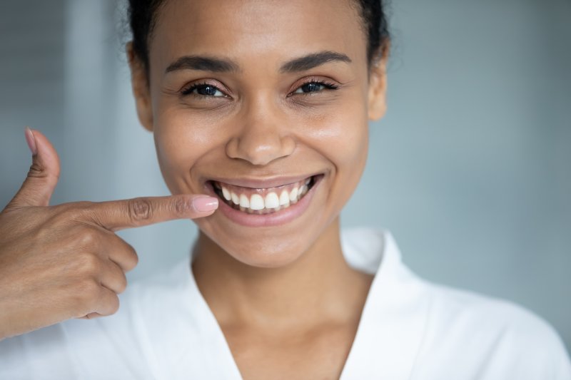 a woman pointing to her straight teeth